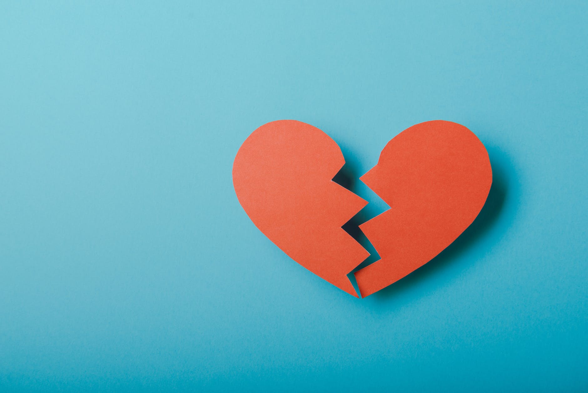 broken paper heart on blue background