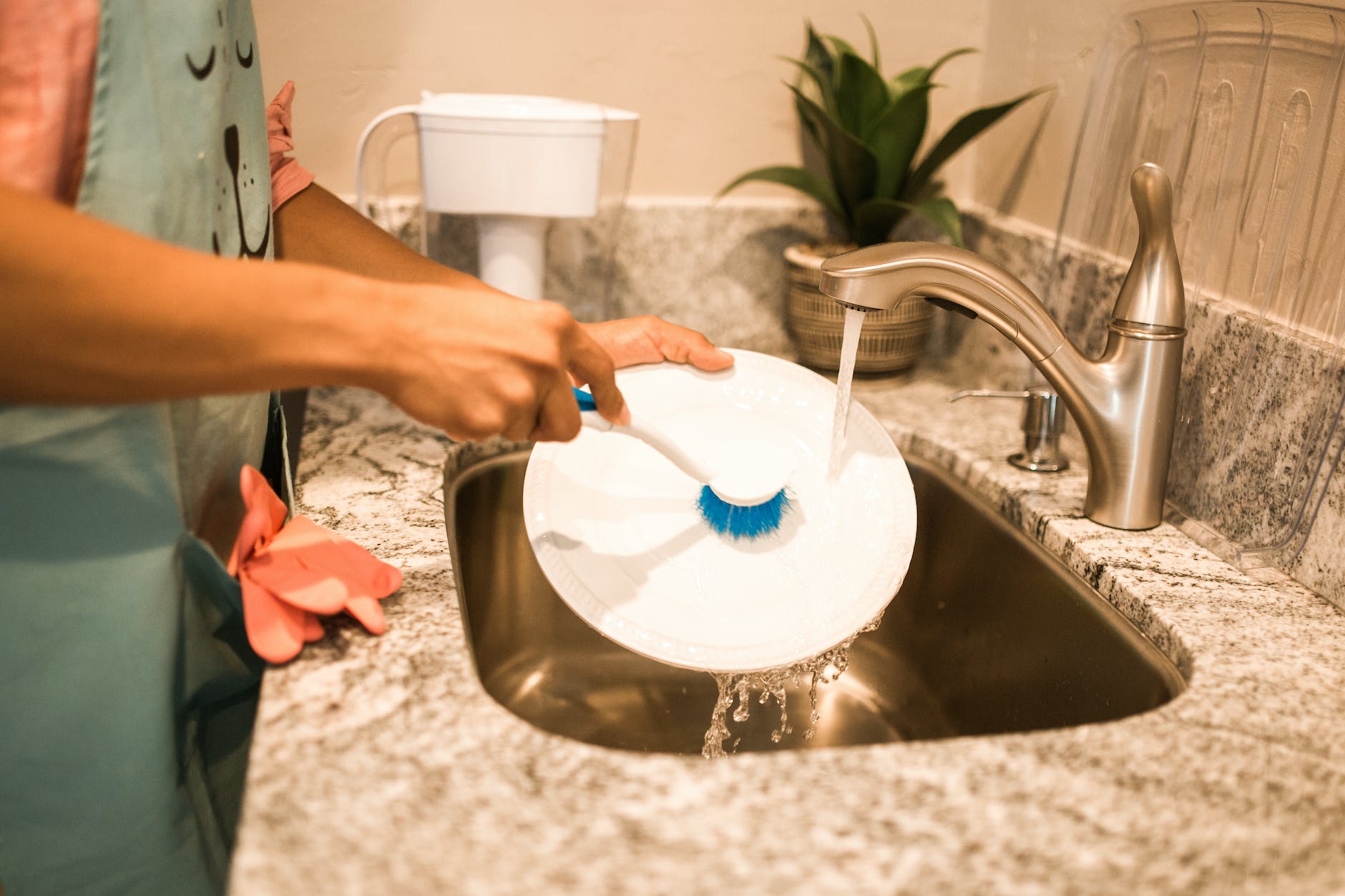 photo of a person s hands washing a white plate